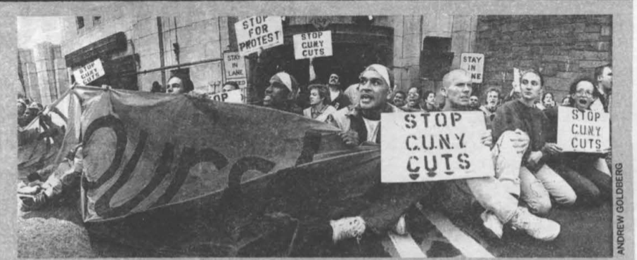 Black and white image of CUNY student protestors, seated, holding signs that say, among others, "Stop the CUNY Cuts"
